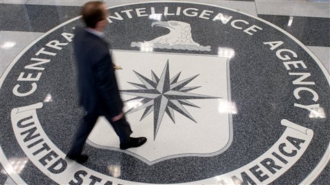 Un homme passe sur le logo de la CIA au quartier général de la CIA en Virginie.