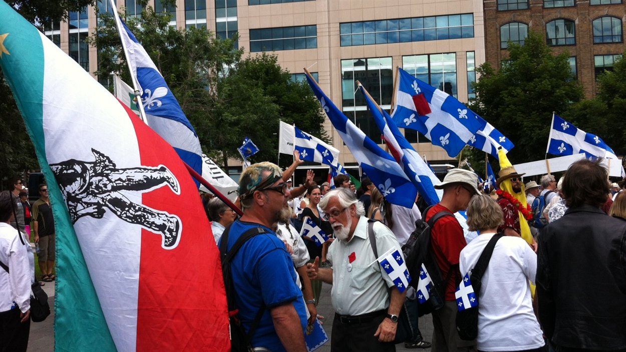 Les manifestants arborent le drapeau québécois et celui des patriotes.