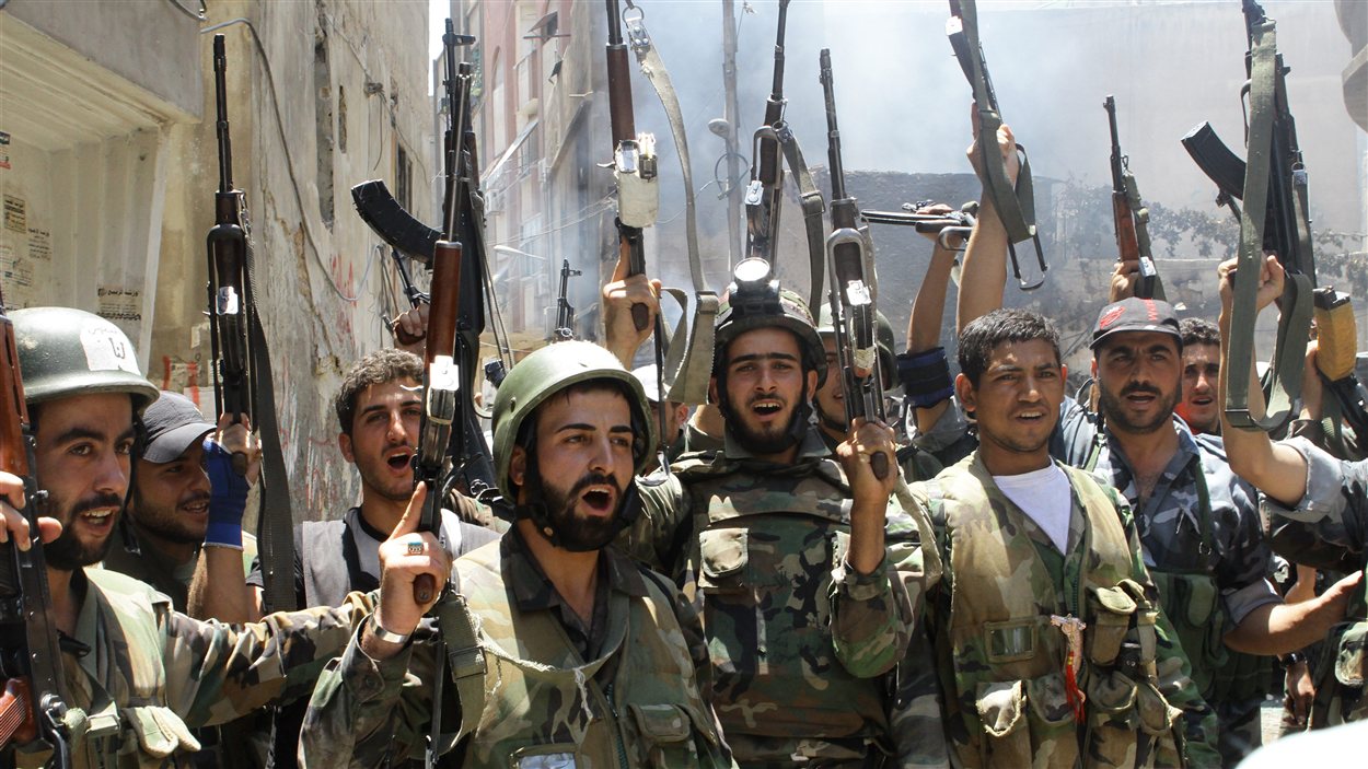 Des soldats de l'armée syrienne célèbrent la reprise du contrôle du quartier de Midane, à Damas.
