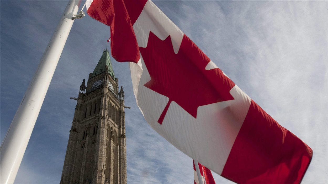 Un drapeau du Canada flotte au vent, sur la colline du Parlement, à Ottawa.