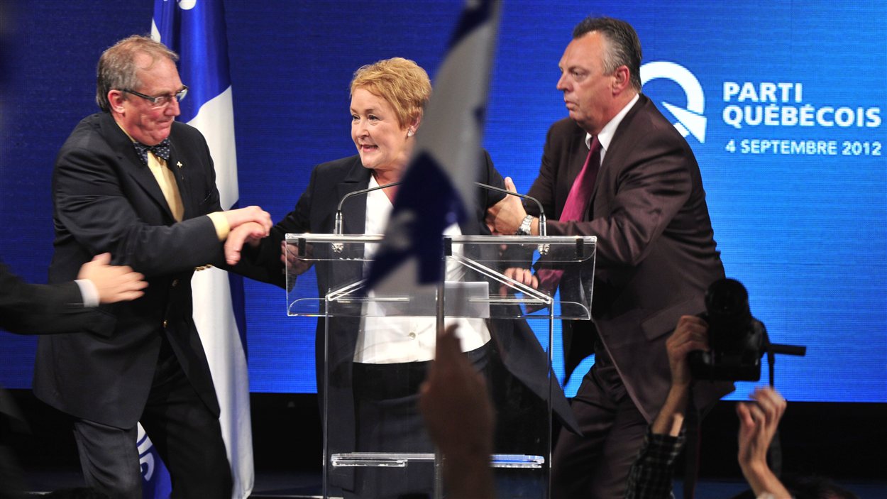 La chef du PQ Pauline Marois est escortée par ses gardes du corps lors de son dicours, le 4 septembre.