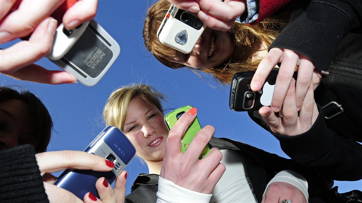 Des jeunes qui utlisent leur cellulaire.