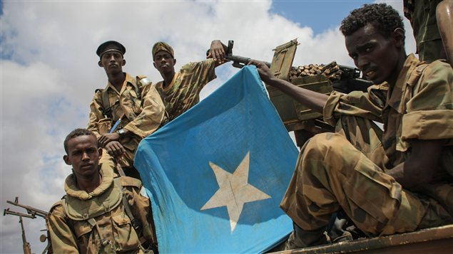 Des soldats somaliens montrent le drapeau somalien lors de leur arrivée à Saamoja, près de Kismayo.  Photo :  AFP/STUART PRICE/UA/ONU