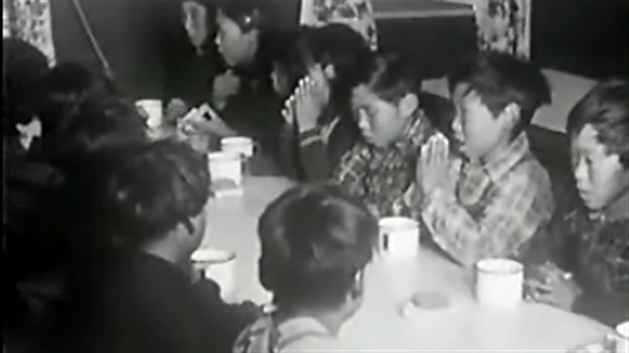 Des élèves d'un pensionnat autochtone au Canada font une prière avant leur repas.