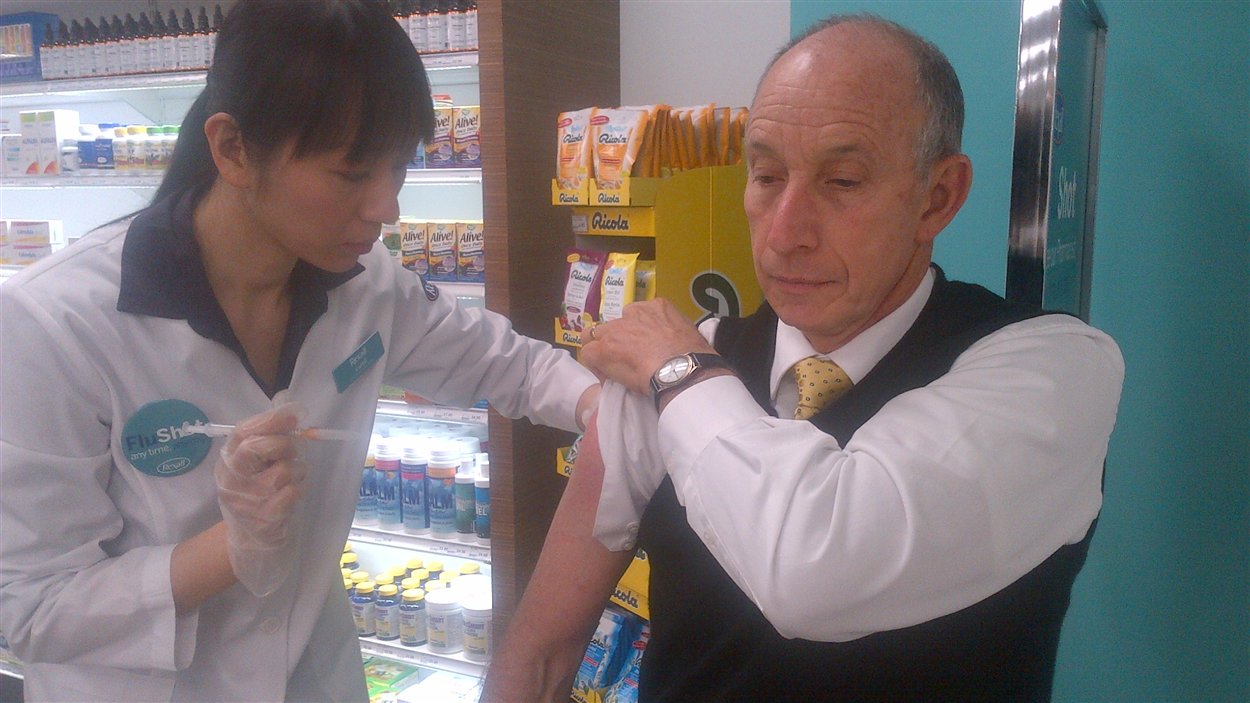Un Torontois se fait vacciner contre la grippe dans une pharmacie.