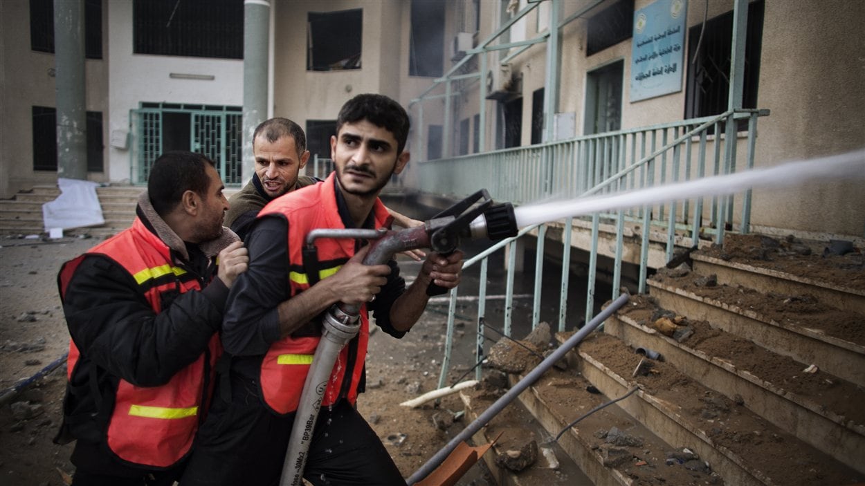 Des pompiers palestiniens tentent d'éteindre un incendie dans les locaux du ministère de l'Intérieur bombardé par les forces israéliennes.
