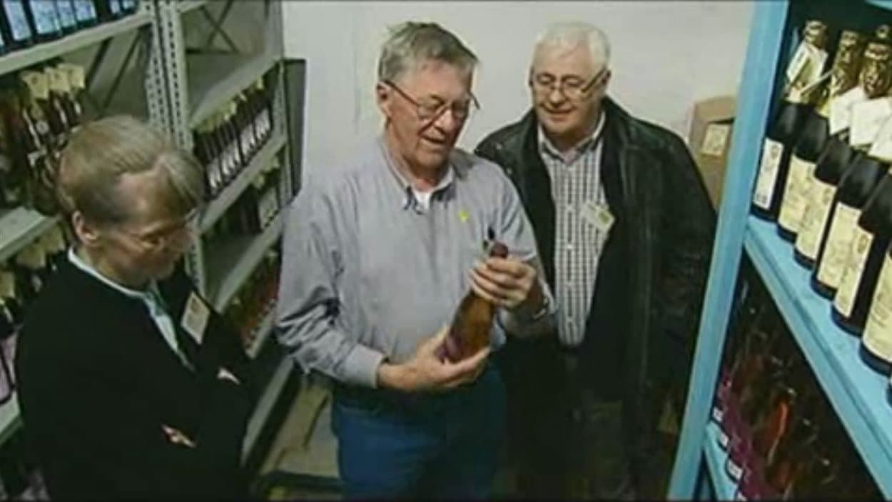 Michel Noël, pomiculteur de Waldheim en Saskatchewan (avant-plan), regarde une bouteille de cidre produit par le pomiculteur Michel Pedneault (arrière-plan), de L'Isle-aux-Coudres dans la région de Charlevoix au Québec, en mai 2010.