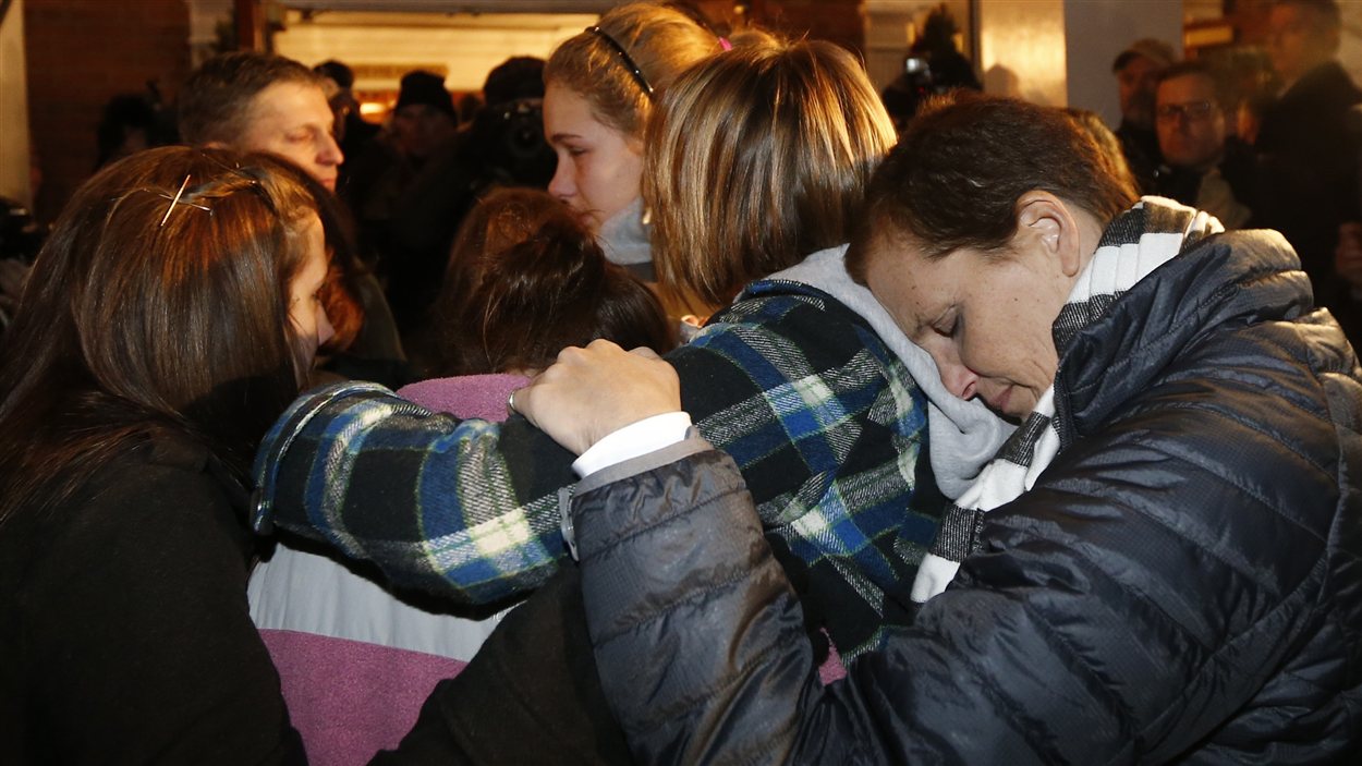Des jeunes filles se réconfortent à l'église Sainte-Rose-de-Lima à Newtown, au Connecticut, lors d'une messe célébrée en hommage aux victimes de la tuerie de l'école Sandy Hook.