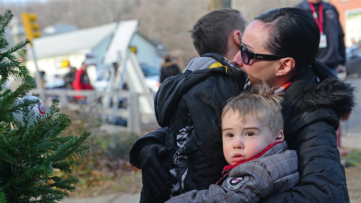 Une mère embrasse ses enfants après un hommage aux victimes de la tuerie.