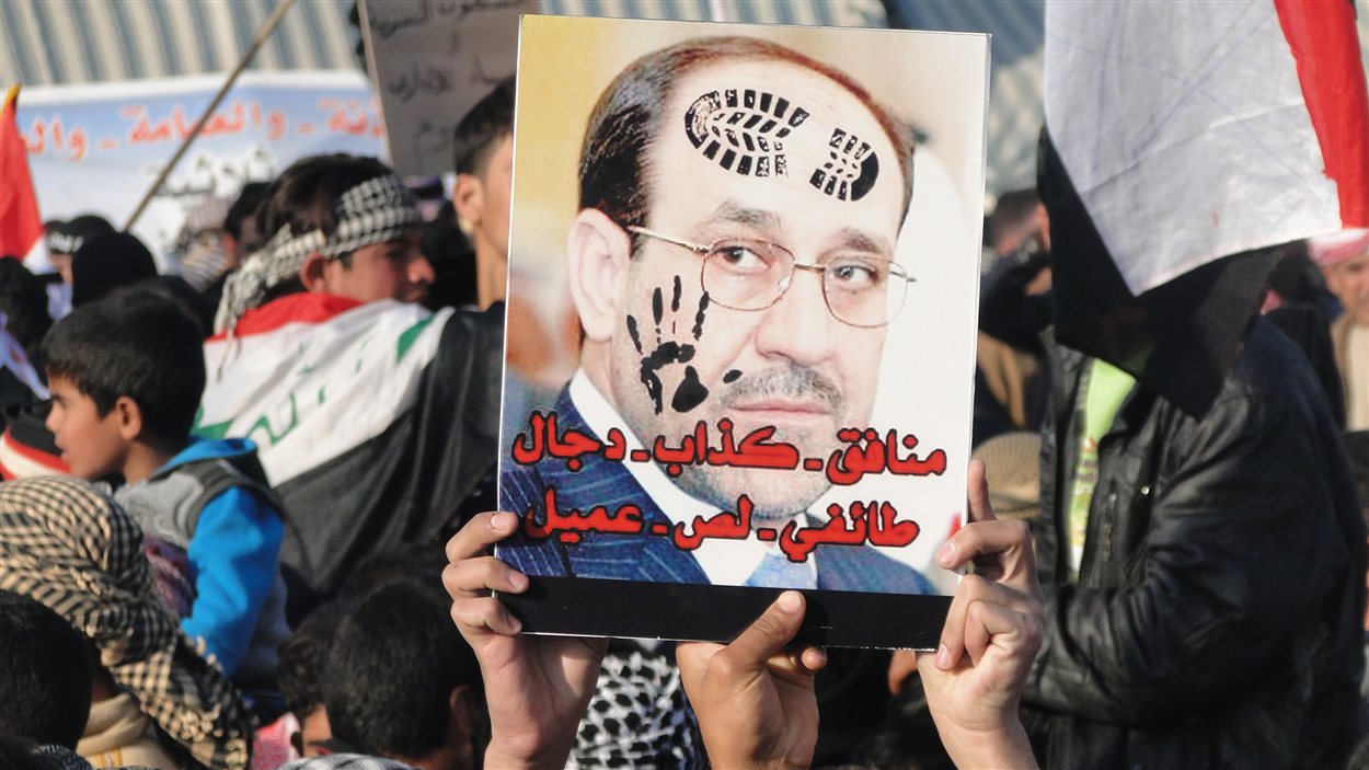 Des manifestants à Ramadi brandissant un portrait d'Al-Maliki où on peut lire « Hypocrite, menteur, sectaire, voleur, traitre »