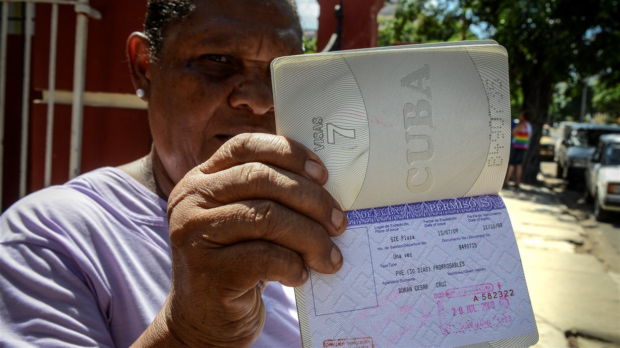 Une Cubaine montre sa carte blanche, un permis de sortie du pays dont les citoyens n'ont désormais plus besoin pour sortir du pays