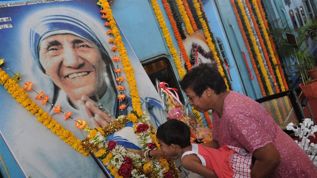 Des Indiens se recueillent devant une image de Mère Teresa