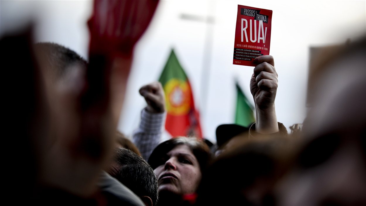 Une manifestante brandie un feuillet avec l'inscription «À bas la troïka» à Lisbonne, le 2 mars 2013