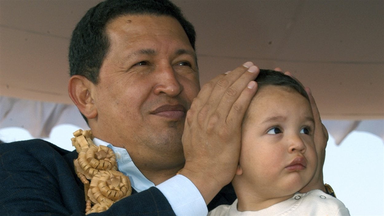  En 2005, Hugo Chavez couvre les oreilles de son petit-fils Manolito lors d'une exposition  aéronautique à l'aéroport de Bangalore en Inde.