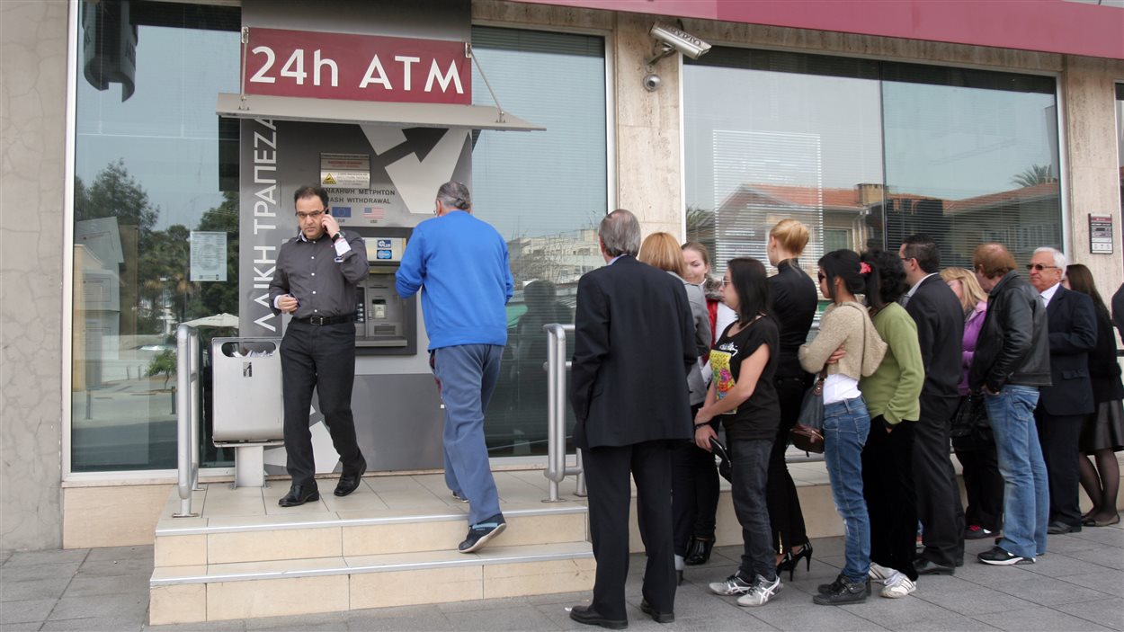 Des Chypriotes font la file devant un distributeur automatique d'une banque, à Nicosie.