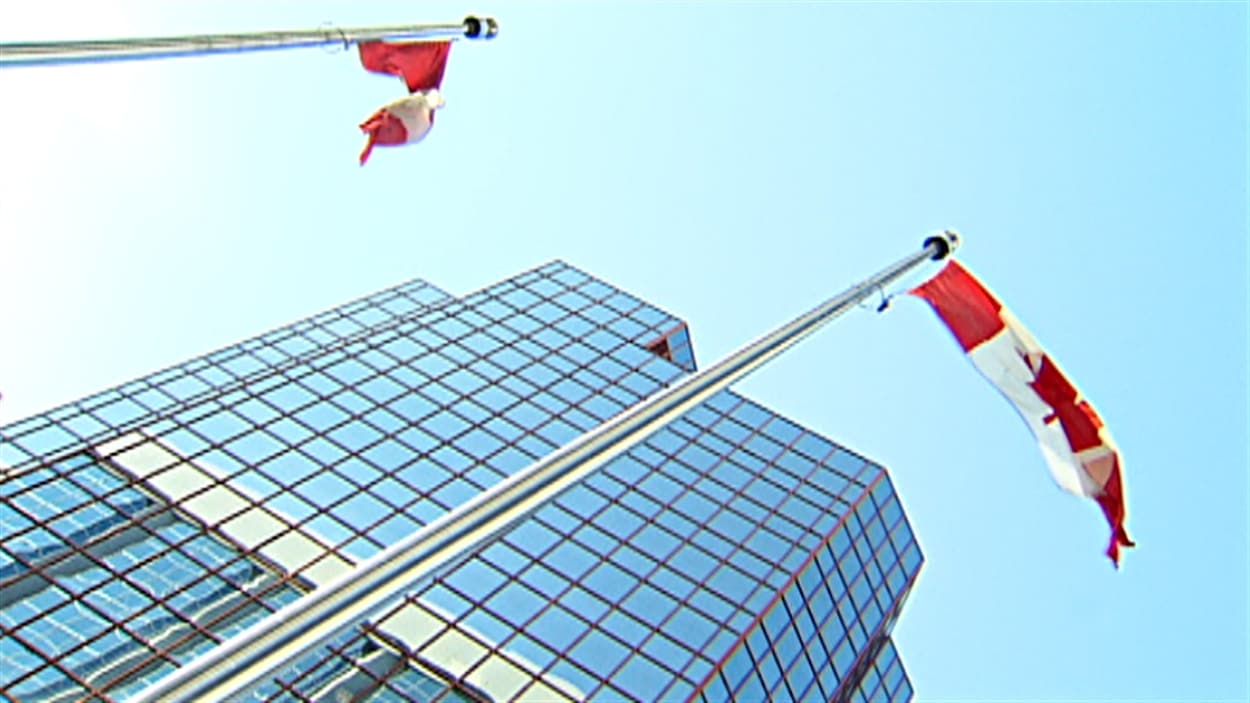Des drapeaux canadiens devant un édifice fédéral à Ottawa.
