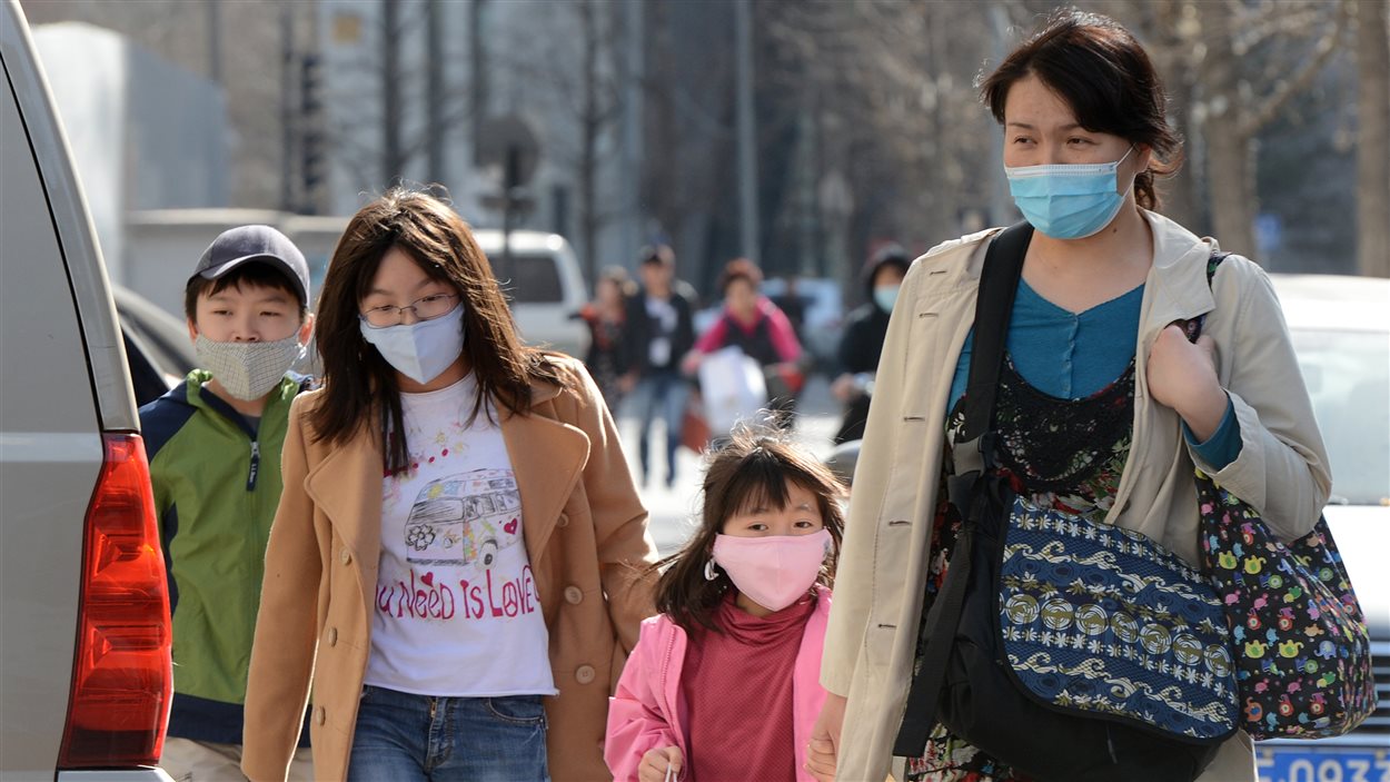 Les membres d’une famille chinoise portent des masques pour se protéger de la pollution de l’air, le 27 mars 2013.