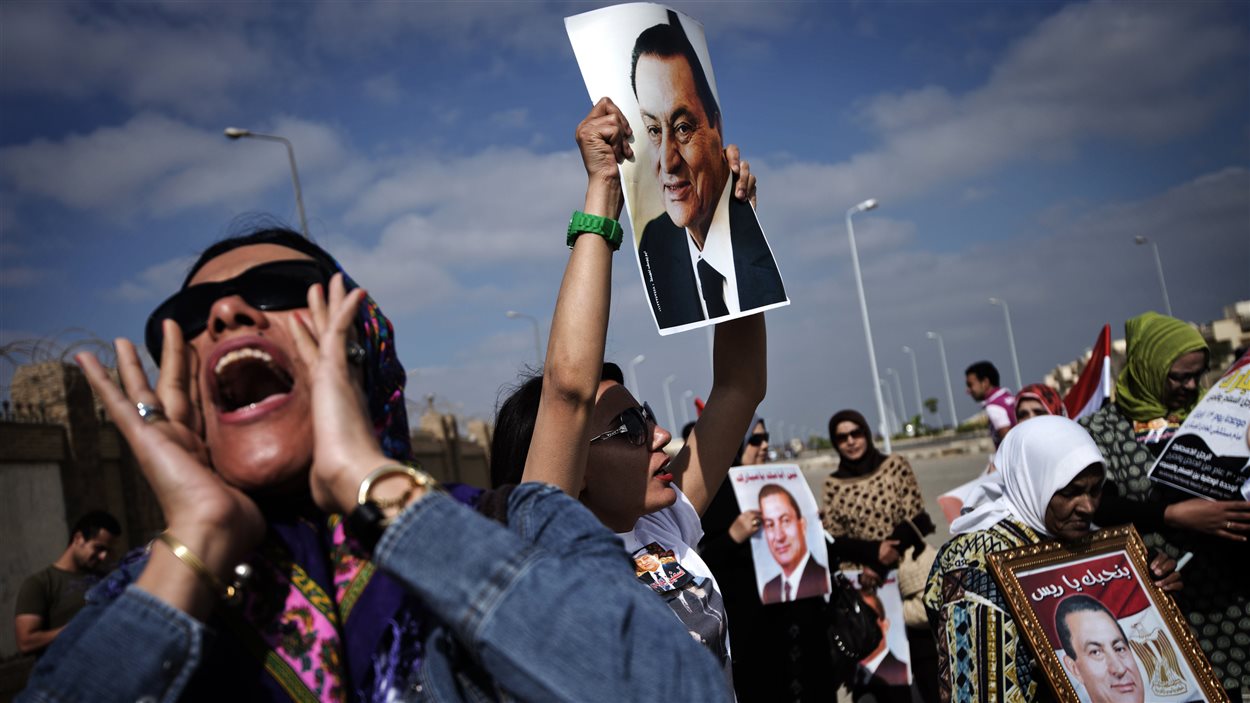 Des partisans d'Hosni Moubarak manifestent devant le tribunal où il devait être jugé, au Caire
