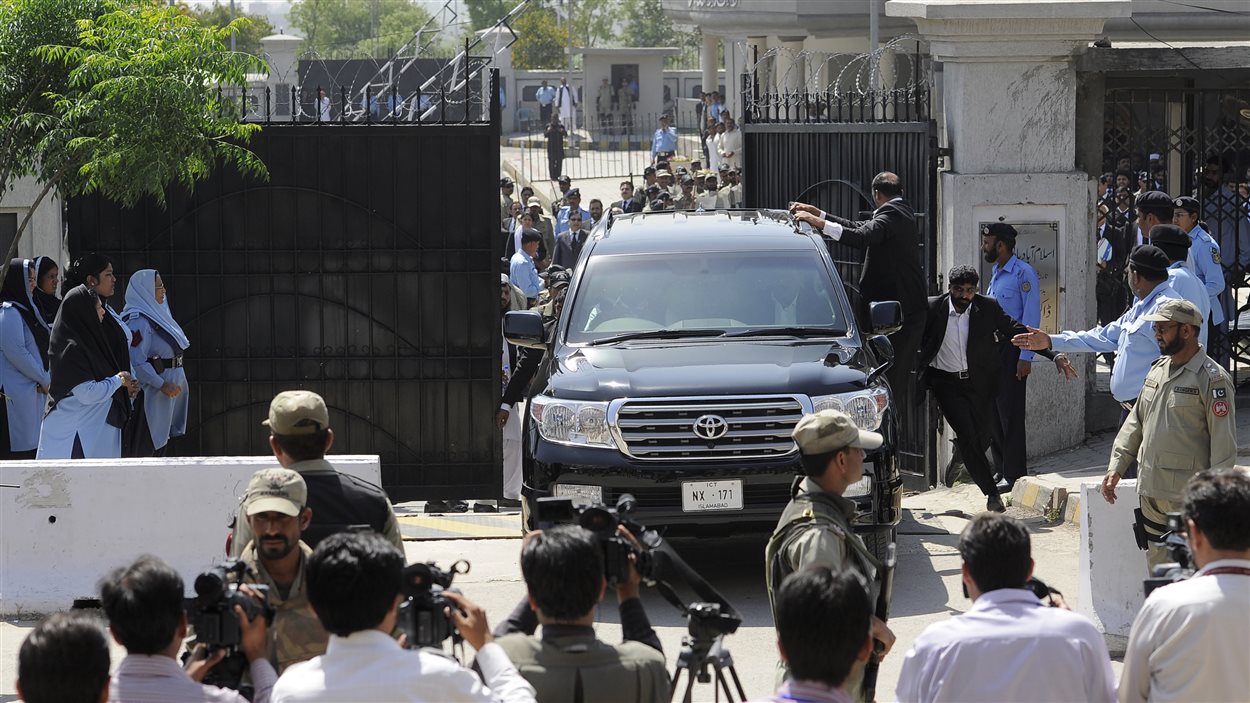 L'ancien président pakistanais Pervez Musharraf et ses gardes du corps prennent la fuite à bord d'une voiture noire.