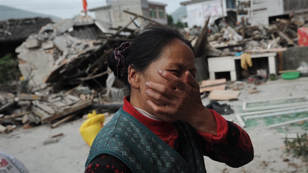 En Chine, une femme pleure après que sa maison eut été détruite par un puissant séisme.