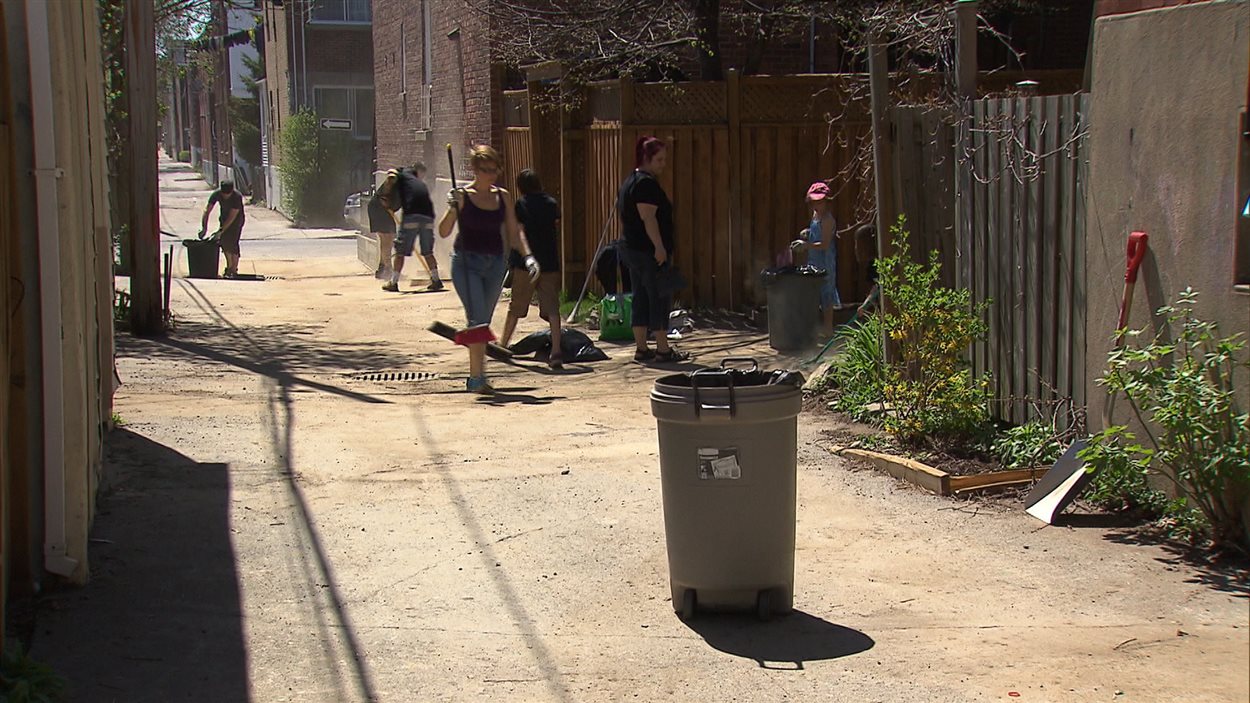 Des Montréalais nettoient leur ruelle.