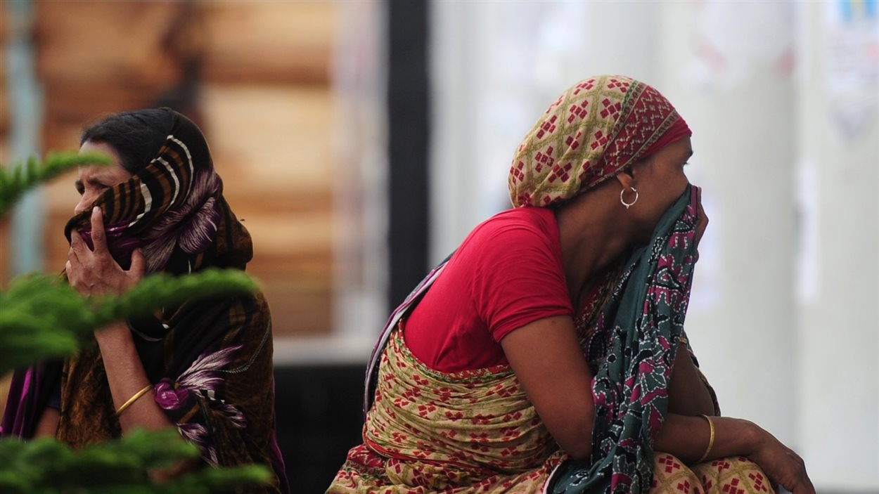 Une famille bangladaise attend que le corps d'un des leurs soit retiré des décombres de l'effondrement, le 7 mai 2013