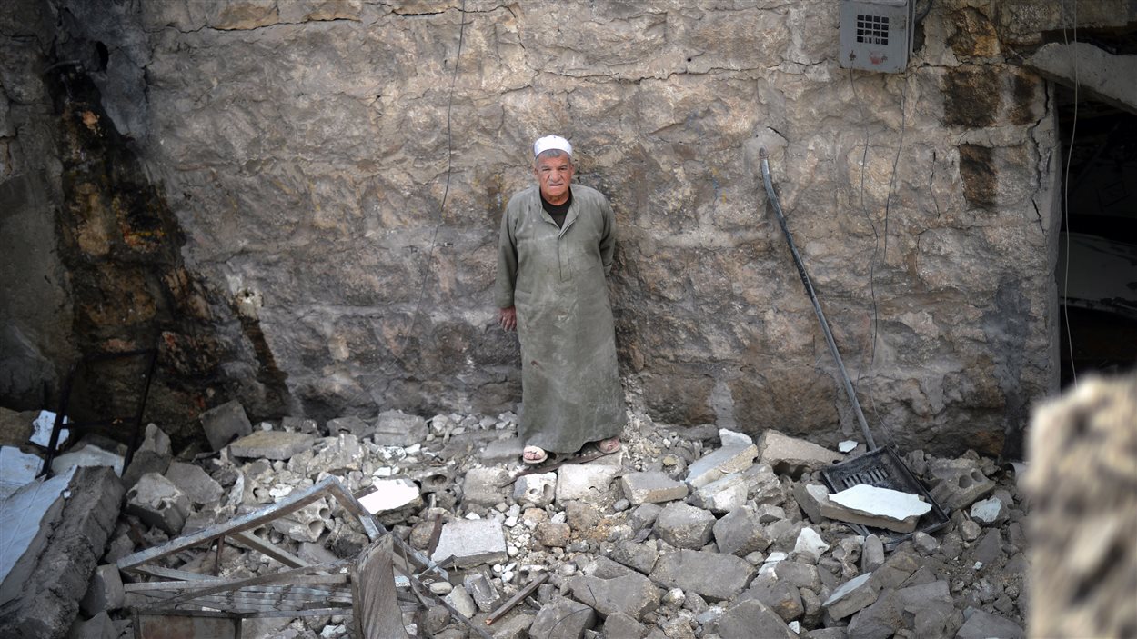 Un homme au milieu des ruines d'une maison à Alep après un bombardement du régime