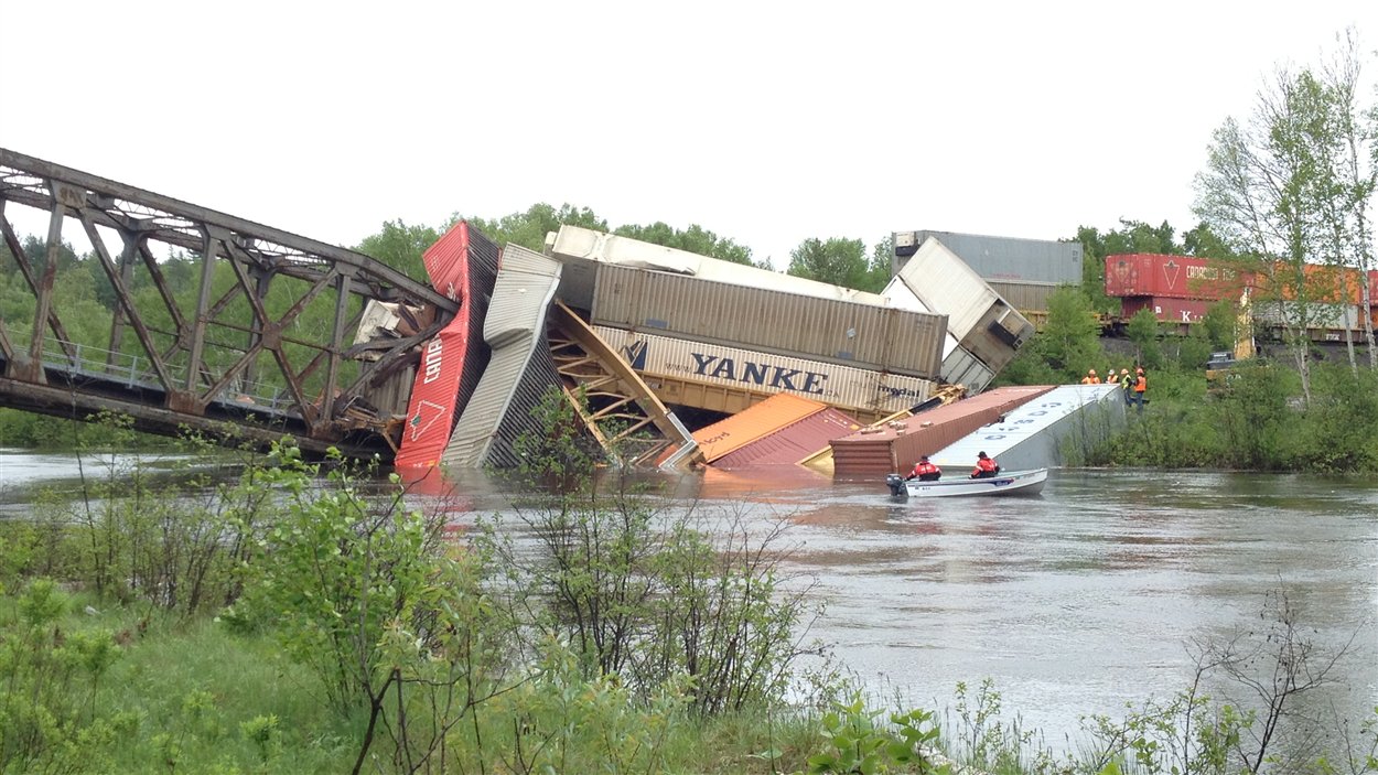 Des wagons du train de marchandise sont tombés dans la rivière lorsque le pont s'est effondré.