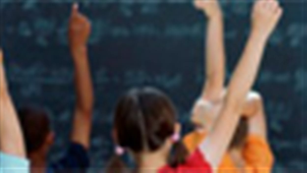 Des élèves lèvent la main pour répondre à une question