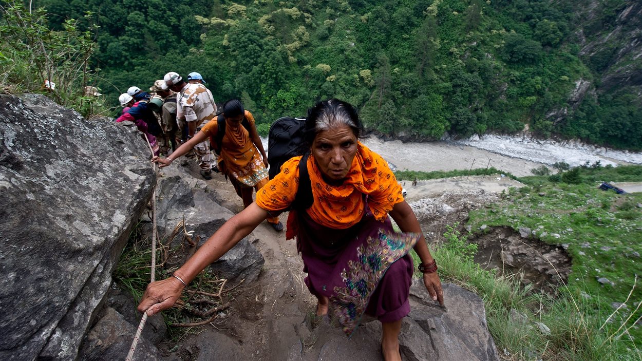 Des Indiens tentent d'escalader une montagne après qu'une partie de la route se soit fait emporter par les eaux à Govind Ghat, le 23 juin 2013