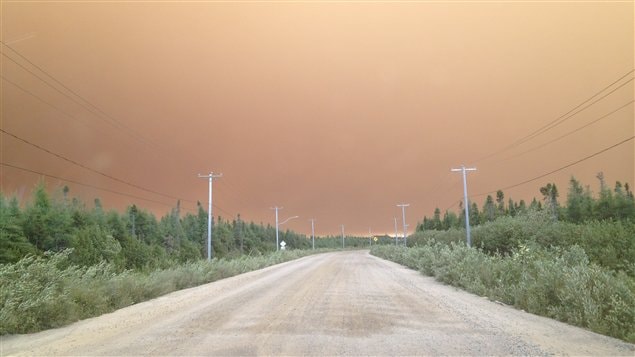 Le ciel est orange au-dessus du village d'Eastmain, qui a dû être évacué en raison de la fumée causée par un feu de forêt.