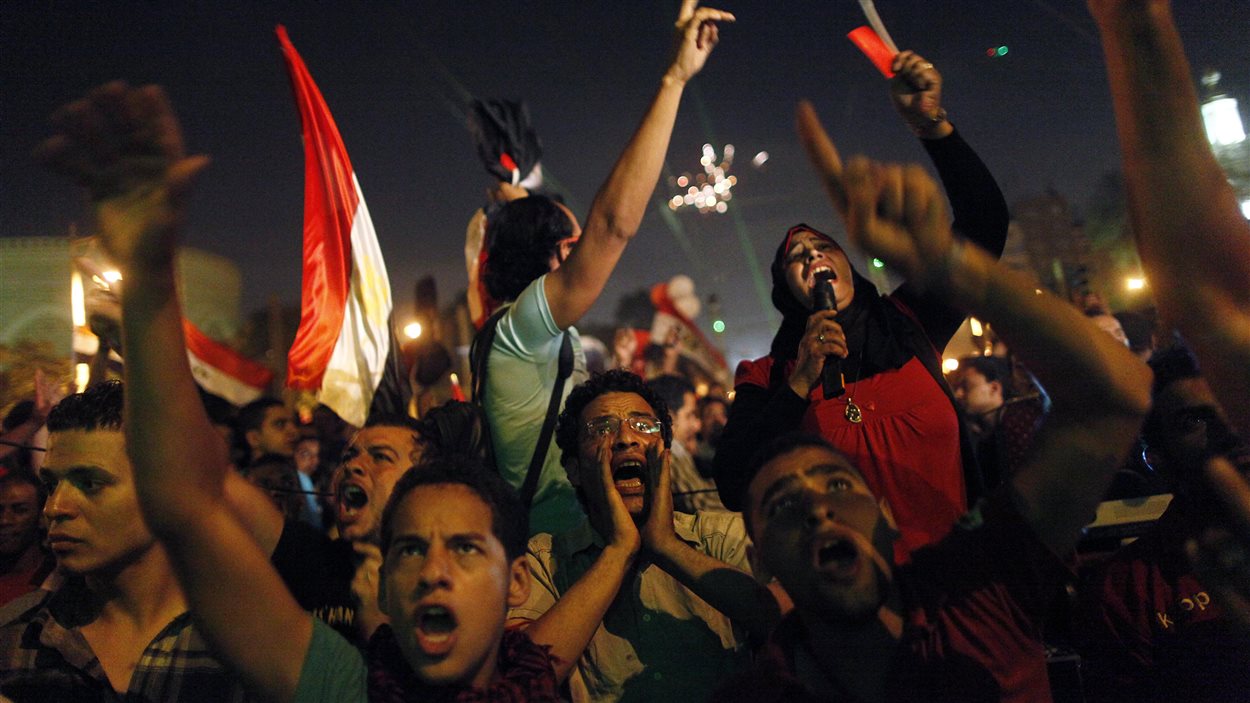 Les Égyptiens protestent au Caire, appelant le président Morsi à la démission alors qu’ils écoutaient son discours sur un écran, mercredi. 