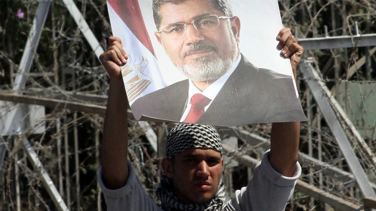 Un partisan de l'ancien président Morsi brandit sa photo en signe de protestation, jeudi au Caire.
