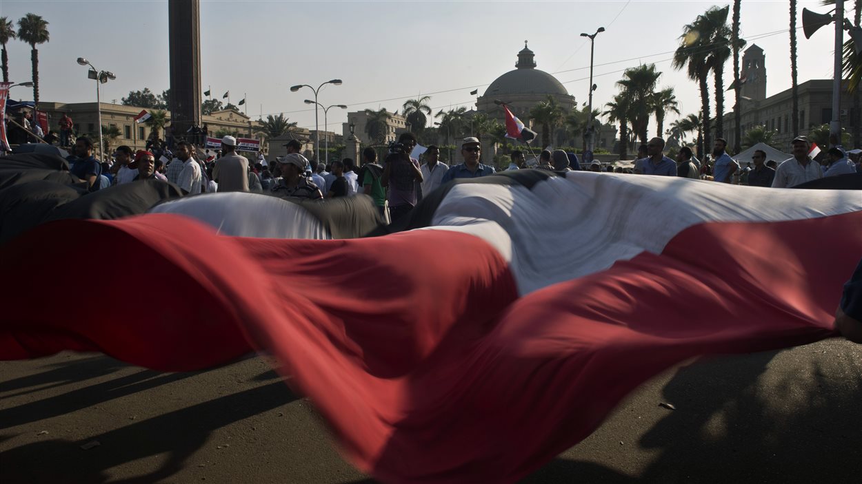 Le drapeau égyptien brandit sur la place Tharir pendant une manifestation.