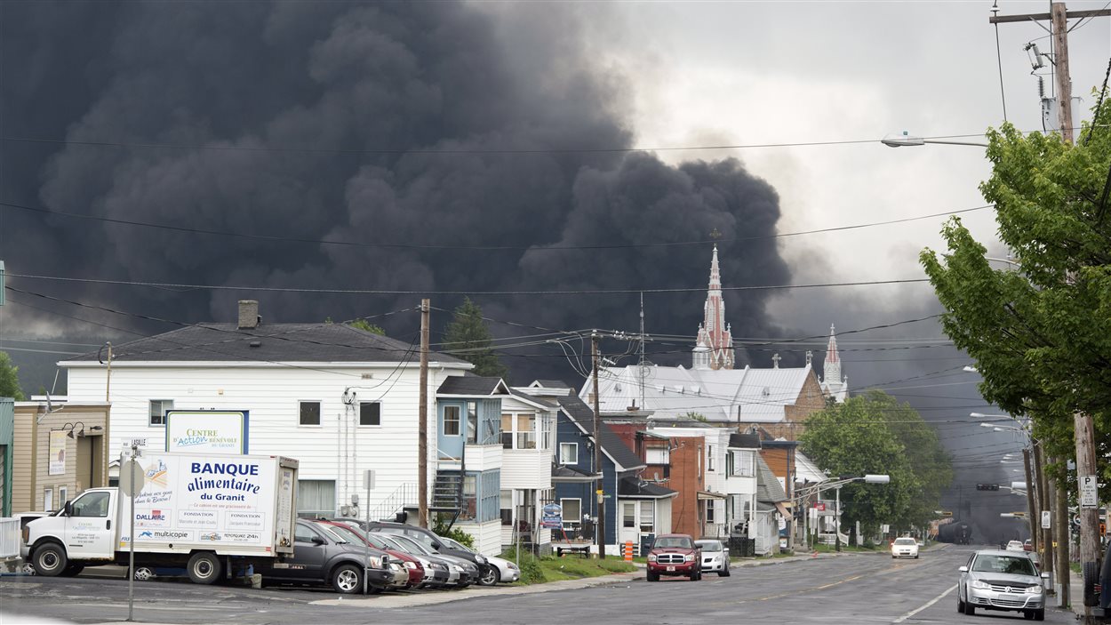 La fumée continue de s'échapper des wagons enflammés à Lac-Mégantic, le 6 juillet 2013