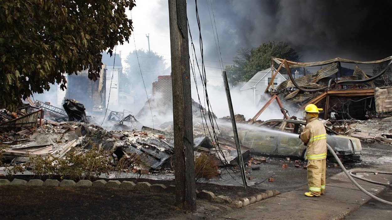 Un pompier arrose les décombres de l'une des nombreuses maisons rasées pa rles flammes.