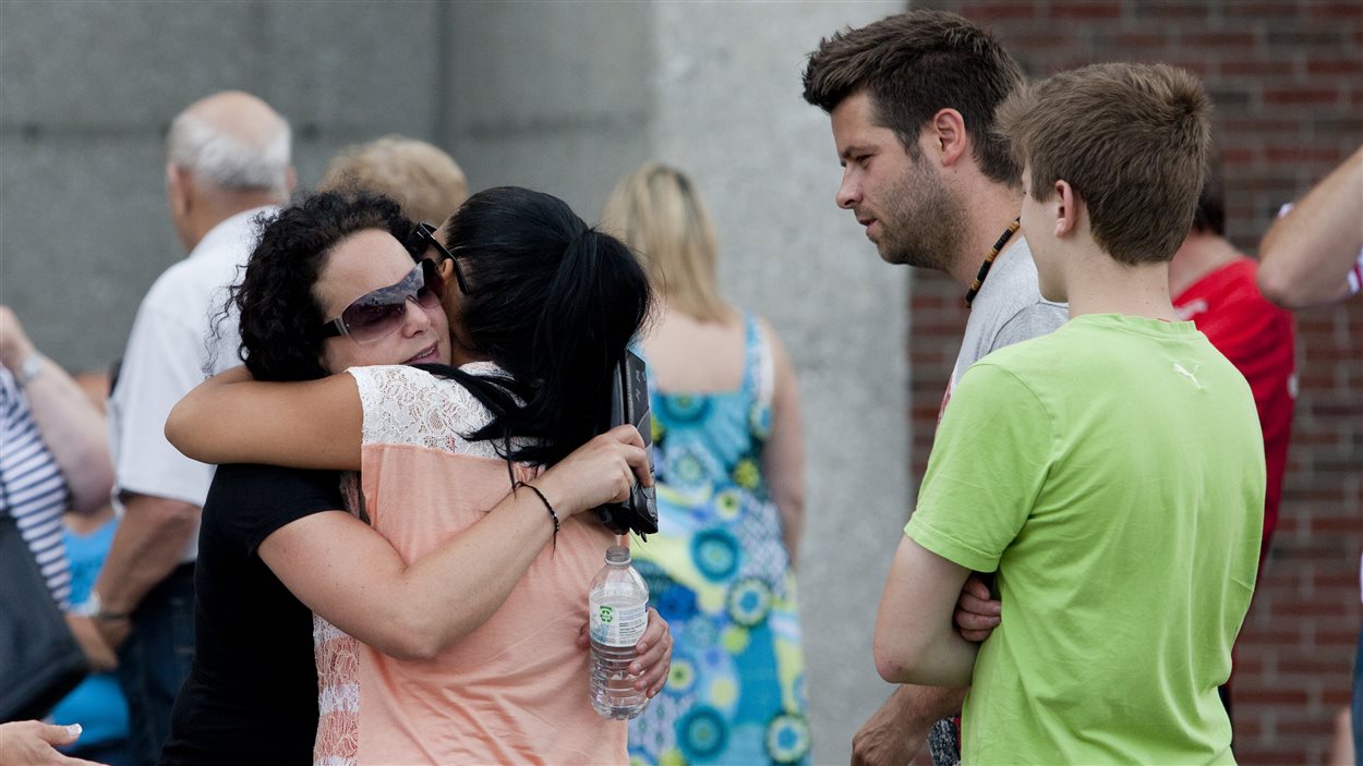 Les membres d'une famille s'étreignent au centre d'urgence aménagé dans la polyvalente Montignac de Lac-Mégantic.