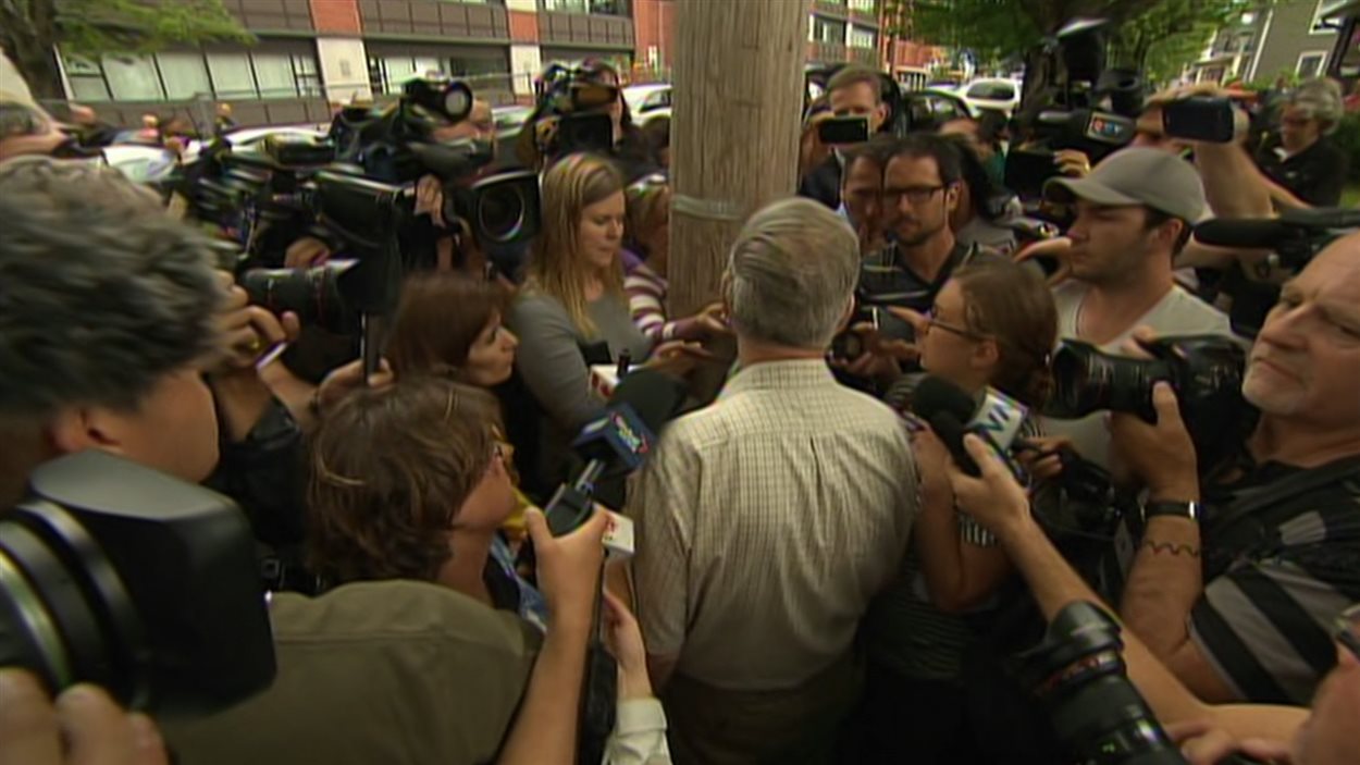 Edward Burkhardt entouré de journalistes à Lac-Mégantic