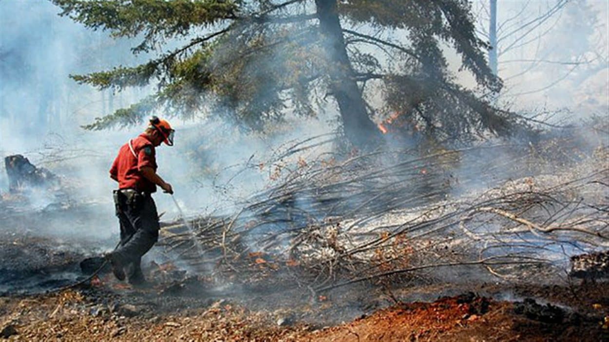 Un pompier éteint un feu de forêt en Colombie-Britannique