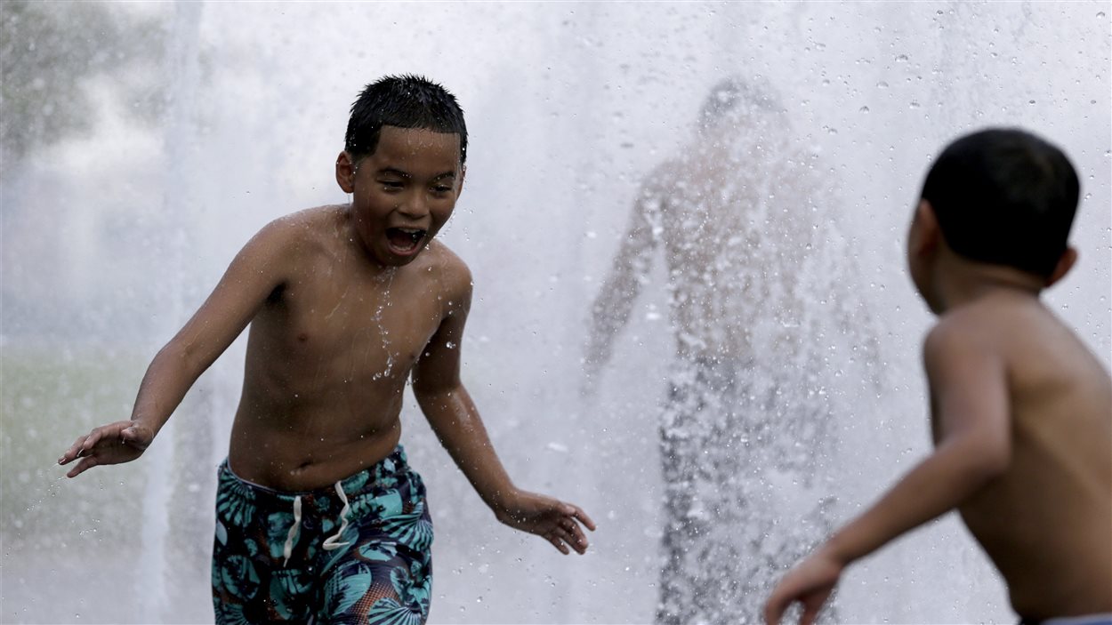 Des enfants se rafraîchissent dans une fontaine au New Jersey. 