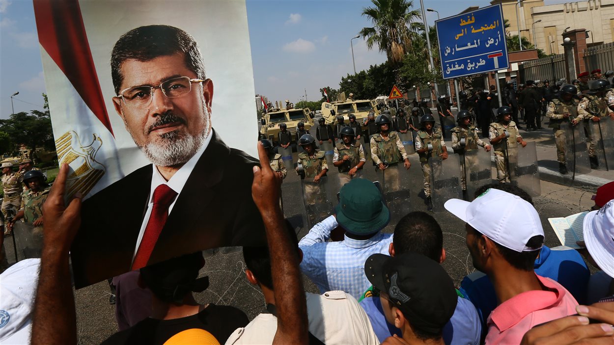 Des partisans des Frères musulmans brandissent une affiche de Mohamed Morsi pour réclamer le retour de ce dernier dans ses fonctions de président.