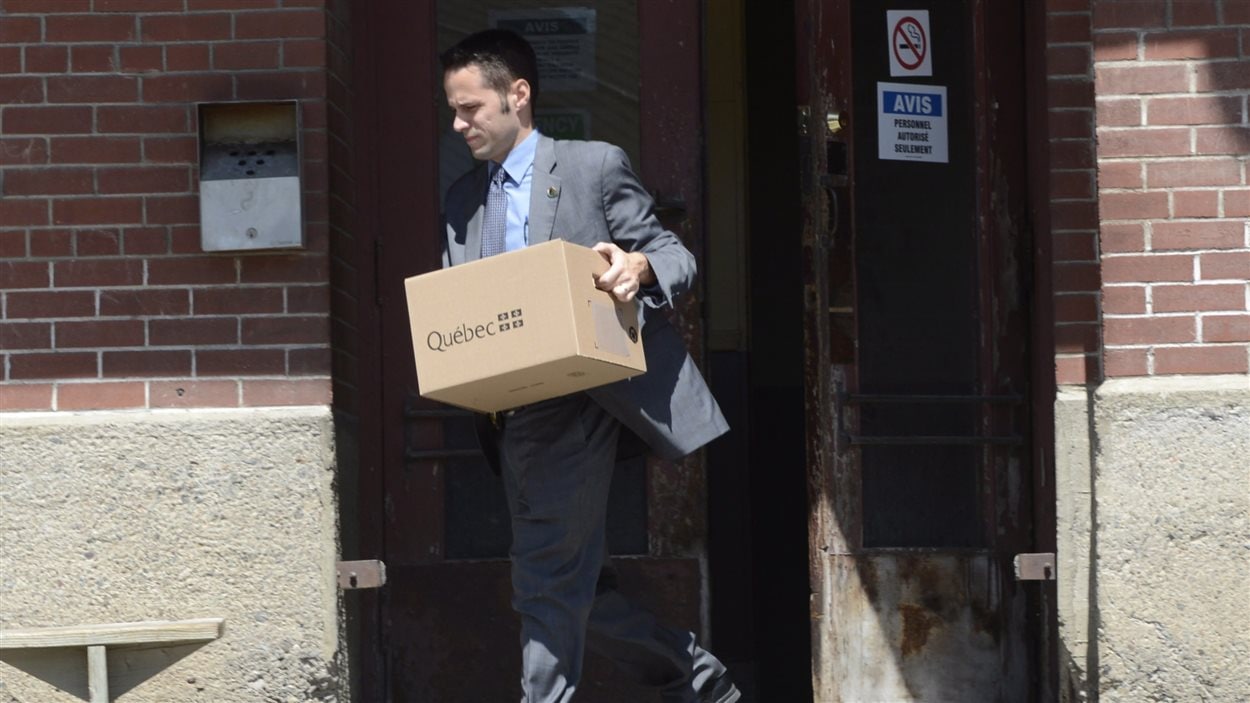 Un inspecteur de la Sûreté du Québec sort des bureaux de la MMA à Farnham