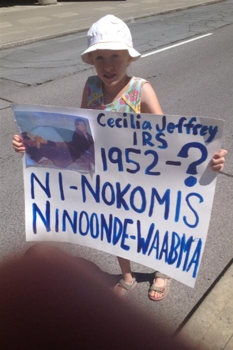 Une jeune participante à l'événement Honour the Apology à Gatineau tient une affiche, le 25 juillet 2013.