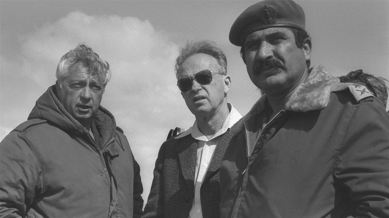 (19 février 1976) Le premier ministre israélien de l’époque, Yitzhak Rabin, en compagnie d’Ariel Sharon et d’Aluf Yekutiel Adam, dans le camp de Tassa dans la péninsule du Sinaï, en Égypte. 