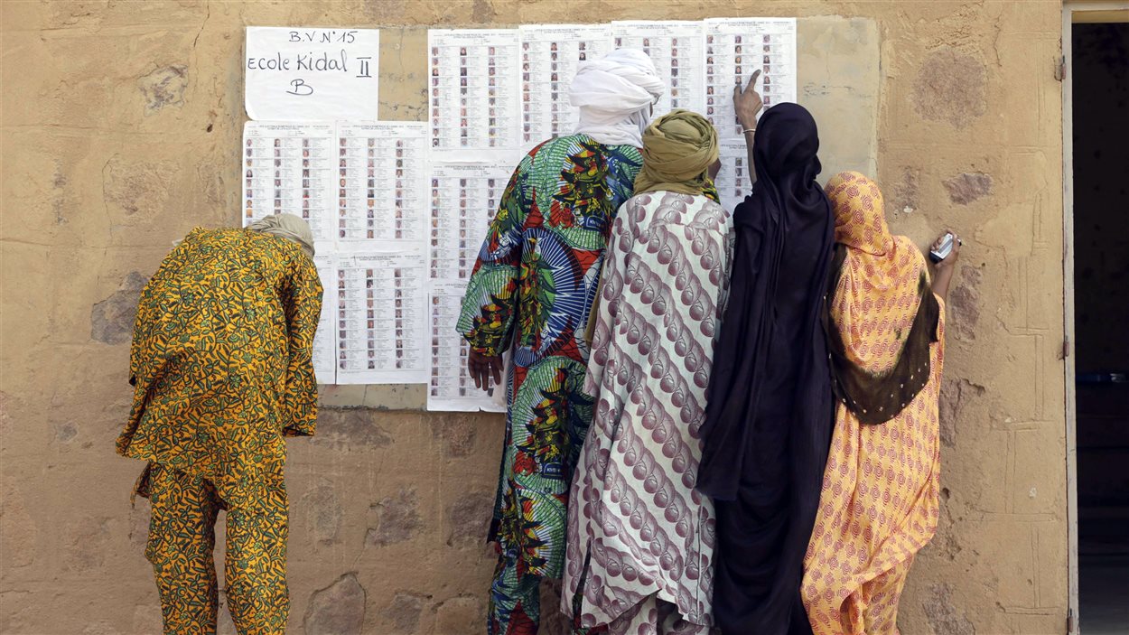 À Kidal, dans le nord du Mali, des électeurs cherchent leurs noms à l'entrée du bureau de vote, le 28 juillet 2013