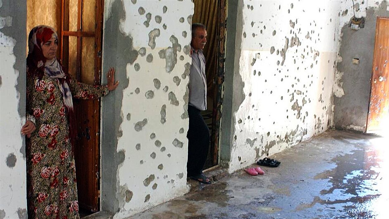 Une femme et son mari devant leur maison après des affrontements entre djihadistes et militants kurdes à Ras al-Aïn, près de la frontière avec la Turquie.