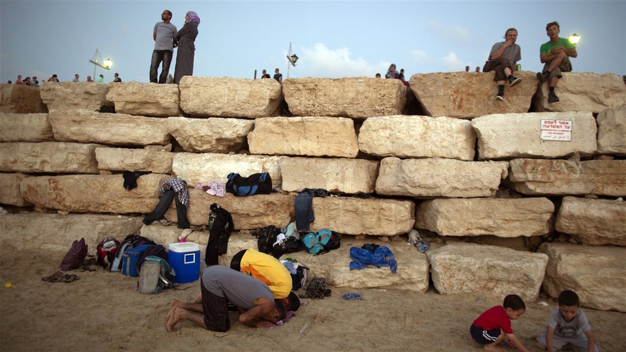 Des Palestiniens prient sur une plage de Tel-Aviv au lendemain de la fin du ramadan