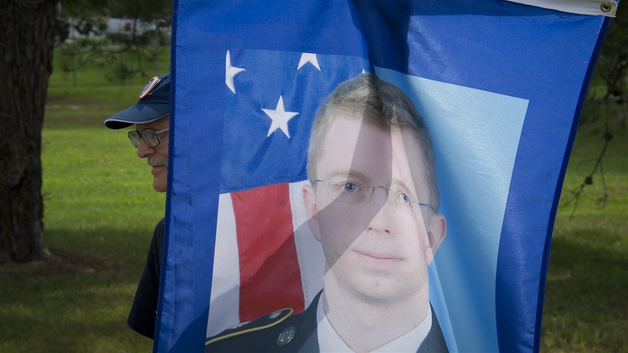 Un partisan de Bradley Manning brandit une affiche du soldat américain devant la cour martiale le 21 août 2013, où il attend sa peine.