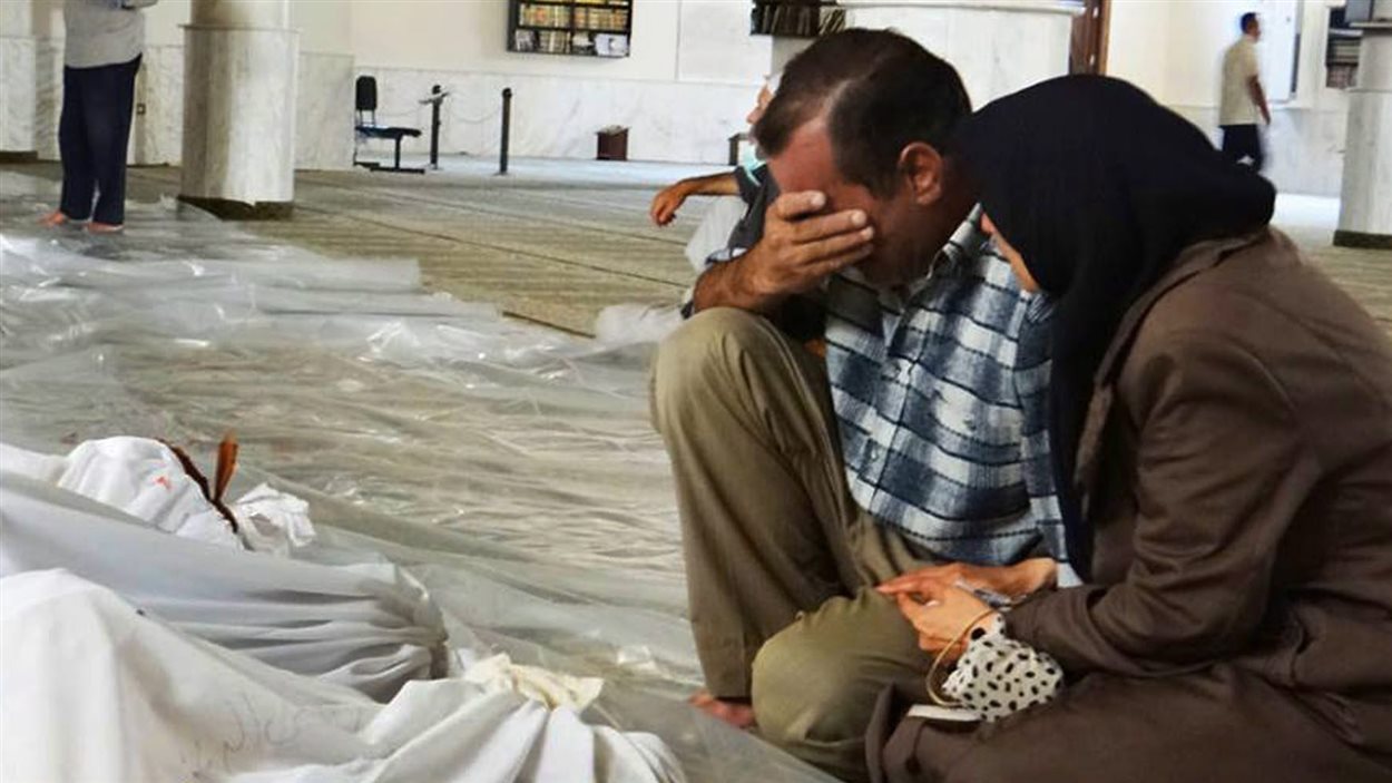 Un homme et une femme pleurent un enfant mort le mercredi 21 août dans ce que l'opposition syrienne qualifie « d'attaque au gaz neurotoxique ».