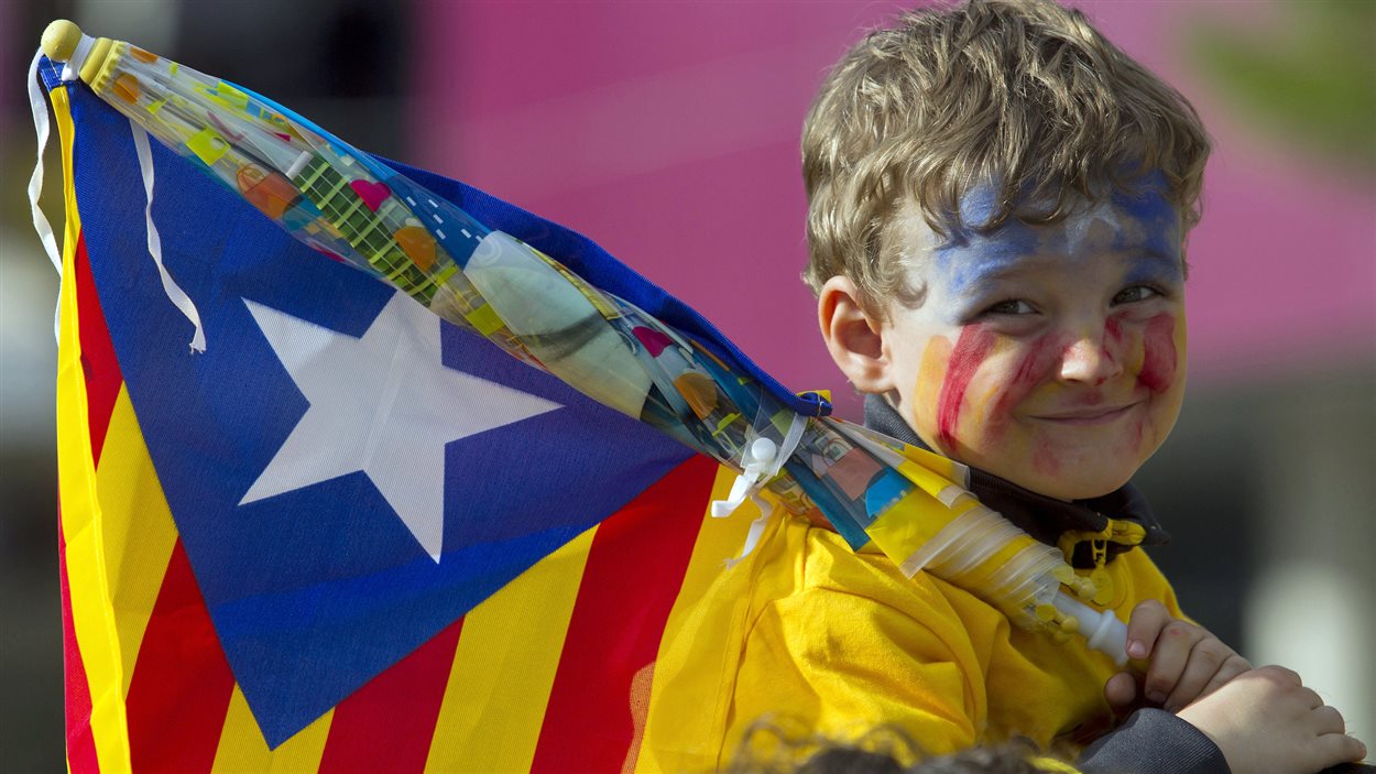 Un jeune garçon tient le drapeau catalan lors d'une grande manifestation du mouvement indépendantiste, le 11 septembre 2013.